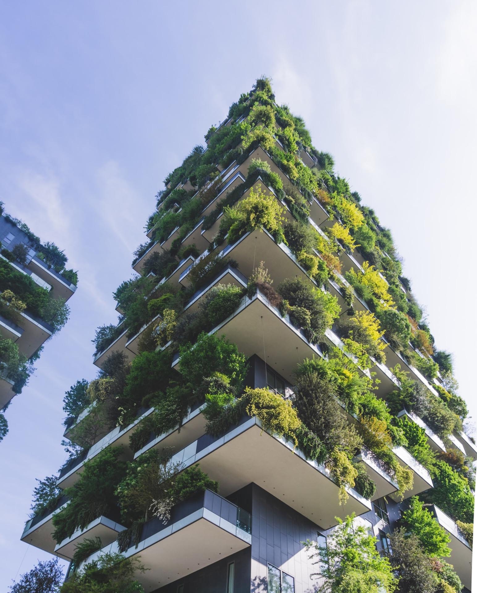 A tall building with lots of plants, showing green living